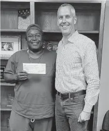  ?? Courtesy Daryl Davis ?? Daryl Davis, left, with state Rep. Matt Schaefer, holds the check for $27,669.86 that he won in a 15-year legal battle with the state.