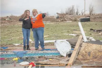  ?? | JESSICA KOSCIELNIA­K/SUN-TIMES PHOTOS ?? Kim Brownfield and her daughter Hannah, 16, walk around the family’s destroyed home on Friday.