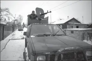  ?? AP/VADIM BRAYDOV ?? A pro-Russia rebel stands guard Tuesday in Vuhlehirsk in eastern Ukraine. U.S. officials say the number of heavy weapons in rebel hands points to Russia’s fueling of rebellion in the region.