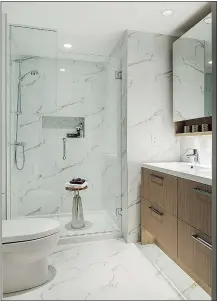  ??  ?? Marble-like porcelain tile is featured on the bathroom floors and walls in Orchid’s residences.