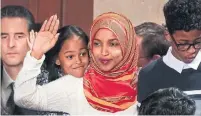  ?? GLEN STUBBE MINNEAPOLI­S STAR TRIBUNE ?? Rep. Ilhan Omar of Minnesota stands with her children at her swearing-in. She’s the first Somali-American representa­tive.