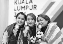  ??  ?? The bowling trio (from left) Esther Cheah, Sin Li Jane and Shalin Zulkifli showing the gold medals that they won in the women’s trio event with 3,835 pins at the Sunway Mega Lanes in Petaling Jaya yesterday. - Bernama photo