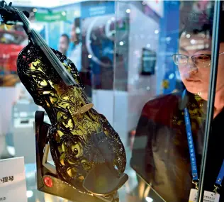  ??  ?? Un violon imprimé en 3D attire l’attention des visiteurs lors de la World Manufactur­ing Convention 2018.
