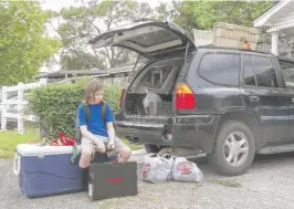  ?? LOLA GOMEZ/AUSTIN AMERICAN-STATESMAN VIA AP ?? Dylan Trotti, 11, sits on an ice chest full of food as his parents prepare to evacuate as Hurricane Laura approaches in West Orange, Texas, on Wednesday.