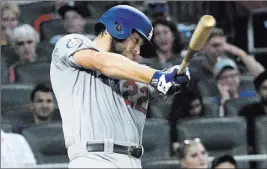 ?? John Amis ?? The Associated Press Dodgers pitcher Clayton Kershaw follows through on a two-run single in the fourth inning of Los Angeles’ 4-1 win over the Braves on Friday night at Suntrust Park.