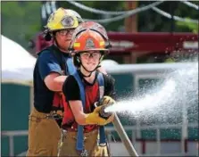  ?? PETE BANNAN-DIGITAL FIRST MEDIA ?? Charles Ziegler of Wagontown Fire Company and Alexandra DiPaolo of the Glen Moore Fire Company advance a hose as part of Chester County Department of Emergency Services’ Junior Public Safety Camp Olympics Thursday at the Chester County Public Safety...