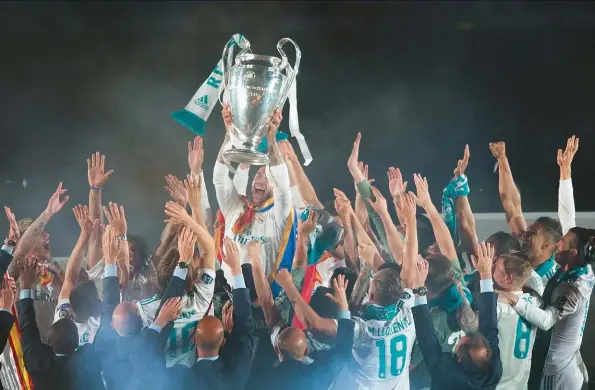  ??  ?? ABOVE: Captain Sergio Ramos lifts the coveted ‘Big Ears’ trophy as he celebrates with his Real Madrid teammates following the Spanish giants’ 3-1 victory over Liverpool in May’s final in Kiev, securing a third successive Uefa Champions League crown and a 13th title in the club’s history.