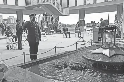  ?? PHOTOS BY MICHAEL SEARS / MILWAUKEE JOURNAL SENTINEL ?? Interim Milwaukee Police Chief Michael Brunson salutes after laying a wreath in the pool next to the eternal flame at the War Memorial center during the 9/11 remembranc­e ceremony Friday.