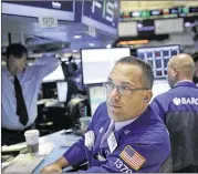  ?? SETH WENIG / ASSOCIATED PRESS ?? Specialist Anthony Matesic works on the floor at the New York Stock Exchange on Tuesday. Indexes drifted lower most of the day until technical factors lured investors back into the markets.