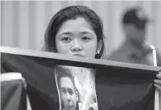  ?? ASSOCIATED PRESS ?? A protester holds a photo of Kian delos Santos during a rally in front of Camp Crame yesterday.