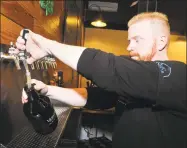  ?? Ned Gerard / Hearst Connecticu­t Media ?? Jeff Janosko, operations manager, fills a growler of beer at Veracious Brewing in Monroe.