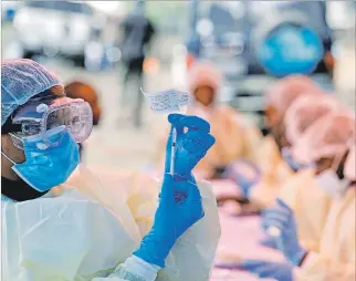  ?? BAZ RATNER / REUTERS ?? Goma. Un trabajador de salud llena una jeringa con la vacuna contra el ébola antes de inyectarla a un paciente.