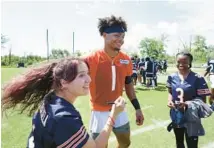  ?? ?? Bears quarterbac­k, Justin Fields, greets Shotwell, right, and Valenzuela, left, during the team’s training camp.