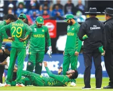  ??  ?? Mohammad Amir (on the ground) hurt his left leg and left the field, when Pakistan and India met during the group stages of the ICC Champions Trophy.