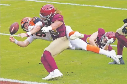  ?? AL DRAGO/ASSOCIATED PRESS FILE PHOTO ?? Bengals quarterbac­k Joe Burrow is stopped short of a touchdown by Washington defensive end Chase Young on Nov. 22 in Landover, Md. Washington won the game, and ever since, Young, a rookie, has wrecked havoc and become a team leader.