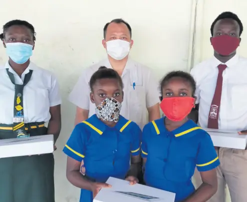  ?? CONTRIBUTE­D ?? Businessma­n Steven Liao with four of the students presented with tablets on the grounds of the May Pen Primary School in Clarendon on Wednesday. More than 100 students were given tablets under the James and Friends Education Programme.