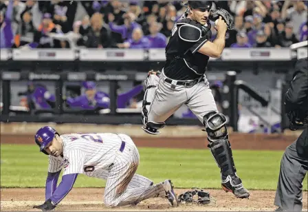  ?? JULIE JACOBSON / AP ?? Marlins catcher J.T. Realmuto leaps over Neil Walker after tagging the plate for a bases-loaded force out in the first inning Sunday.