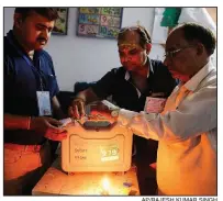  ?? AP/RAJESH KUMAR SINGH ?? Election officers in Varanasi, India, seal an electronic voting machine Sunday at the end of polling in the final phase of the country’s national elections.