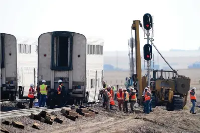  ?? The Associated Press ?? ■ Workers examine a train car on Monday from an Amtrak train that derailed Saturday near Joplin, Mont. Federal investigat­ors are seeking the cause of the derailment.