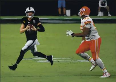  ?? PHOTOS BY ETHAN MILLER — GETTY IMAGES ?? Raiders quarterbac­k Derek Carr (4) scrambles under pressure from Kansas City Chiefs defensive tackle Chris Jones (95) in the first half of their game at Allegiant Stadium on Sunday in Las Vegas. The Chiefs defeated the Raiders 35-31.
