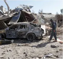  ?? (Ahmad Nadeem/Reuters) ?? AN AFGHAN POLICEMAN inspects a damaged vehicle at the site of a blast in Kandahar yesterday.