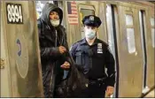  ?? PTI ?? A man is removed from a train by a New York Police officer at the Coney Island Stillwell Avenue Terminal, Wednesday, in the Brooklyn borough of New York