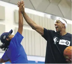  ??  ?? Colby Bear really has to stretch for a high five from Jerome Williams.