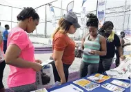  ??  ?? Fit 4 Life participan­ts getting their health and fitness handouts and compliment­ary newspaper from The Gleaner booth.