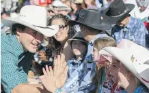  ?? CRYSTAL SCHICK/ CALGARY HERALD ?? Justin Trudeau high fives kids at the 2014 Stampede Parade.