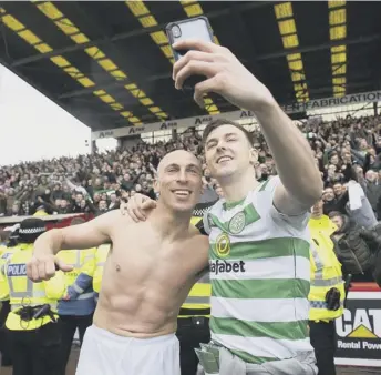  ??  ?? 0 Captain Scott Brown and full-back Kieran Tierney pose for a selfie in front of the Celtic fans as manager Neil Lennon’s team celebrate clinching their eighth league title in a row following their 3-0 victory over Aberdeen at Pittodrie on Saturday.