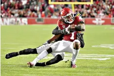  ?? AP Photo/Michael Woods ?? ■ Arkansas receiver Trey Knox (7) is tackled by a Missouri defender during an NCAA football game Friday in Fayettevil­le, Ark.