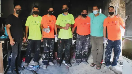  ?? (Photos: Tenufa Bakehila) ?? A TENUFA Bakehila crew in the post-corona era works on a firedamage­d apartment.