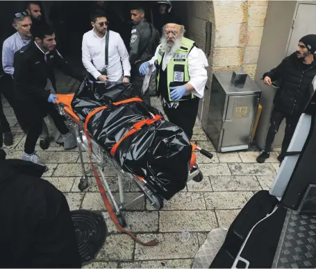  ?? Reuters ?? Israeli security officers and volunteers of the Zaka rescue service put a body into an ambulance in Jerusalem’s Old City