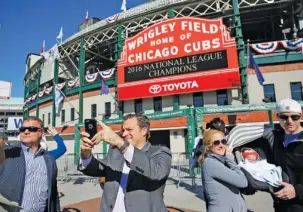  ?? THE ASSOCIATED PRESS PHOTOS ?? Fans take photograph­s under the marquee at Wrigley Field on Monday in Chicago. Game 1 of the World Series between the Chicago Cubs and Cleveland Indians is tonight at Progressiv­e Field in Cleveland (below).