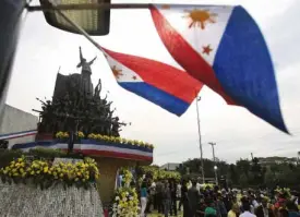  ?? MARIANNE BERMUDEZ ?? QUIET DAY AT EDSA Philippine flags flutter in the wind during the celebratio­n of the 28th anniversar­y of the Edsa uprising at the People PowerMonum­ent along Edsa inQuezon City.