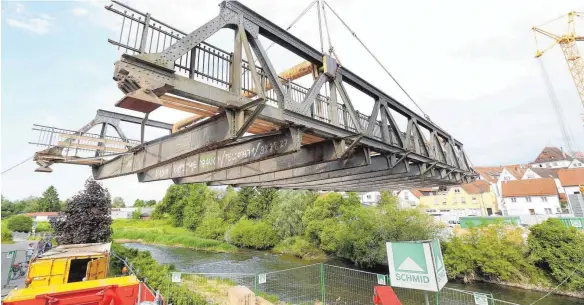  ?? FOTOS: THOMAS WARNACK ?? Wie leicht es aussieht: Die 75-Tonnen-Brücke ist am Dienstagmo­rgen von einem Spezialkra­n aus der Verankerun­g gehoben worden.