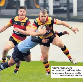  ??  ?? Carmarthen Quins scrum-half Jon Evans tries to escape a Bargoed tacklePict­ures: Phil Davies