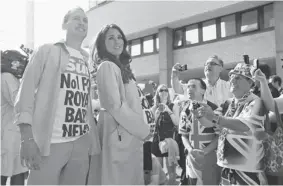  ?? LEFTERIS PITARAKIS/THE Associated Press ?? Royal supporters, right, look on as a couple impersonat­e Britain’s Prince William and Kate,
the Duchess of Cambridge as they pose for photograph­ers, during a publicity stunt.