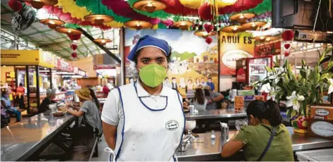  ?? Photos by Eva Lepiz / Washington Post ?? Not all visitors to 20 de Noviembre Market wear masks, as Marina Gonzales Camarillo must as a waitress in Oaxaca, Mexico.