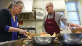  ?? CATHIE COWARD, THE HAMILTON SPECTATOR ?? Glenn Leman, new director of Hamilton Out of the Cold, and executive director Janice Ormond chop up cantaloupe for Saturday night’s dinner at MacNab Presbyteri­an Church.