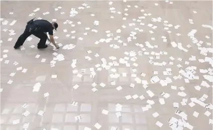  ?? Picture: EPA-EFE ?? LITTER LOUTS. A US Capitol police officer picks up fliers that were thrown by people demonstrat­ing against US President Donald Trump’s nomination of Brett Kavanaugh to be a Supreme Court justice.