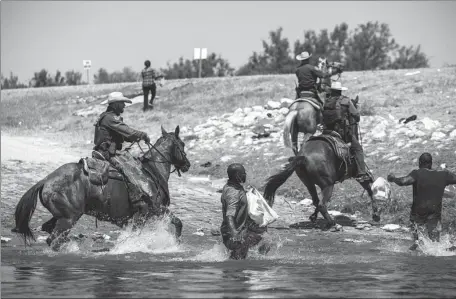  ?? FELIX MARQUEZ / ASSOCIATED PRESS ?? US Customs and Border Protection mounted officers attempt to stop migrants as they cross the Rio Grande river from Ciudad Acuna into Del Rio, Texas, on Sunday.