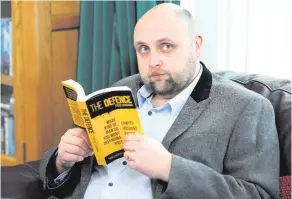  ??  ?? Engaging read: author Steve Cavanagh with a copy of his first novel, The Defence