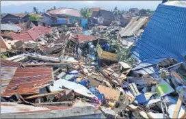  ?? REUTERS ?? People search through debris following the earthquake and tsunami in Palu, central Sulawesi.