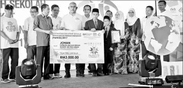  ??  ?? Noh presenting a prize to recycling competitio­n champion after launching the National Recycling Day. — Bernama photo