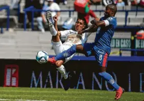  ?? Anthony Vázquez / Associated Press ?? Dorlan Pabón (der.), de Monterrey, intenta una chilena frente a la marca de Idekel Domínguez, de Pumas, en el empate 1-1 el domingo en México.