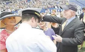  ?? JOSHUA MCKERROW /CAPITAL GAZETTE ?? Senator John McCain, right, places a hat on the head of his son John McCain IV after his commission­ing at the USNA Class of 2009 graduation in Annapolis.