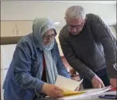  ?? DEREK GEE, BUFFALO NEWS ?? Turkish immigrant Incilay Kircali, centre, and her husband Hakan review paperwork as Incilay applies for asylum in Canada at the Newcomer Centre at the Peace Bridge in Fort Erie, Ont.