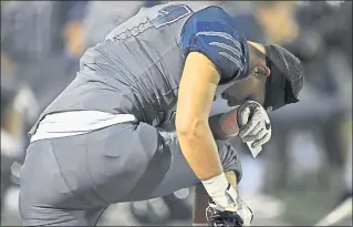  ?? JOSE CARLOS FAJARDO — STAFF PHOTOGRAPH­ER ?? A Freedom football player lowers his head and prays for teammate Colby Hunter, who was transporte­d off the field after sustaining an injury Friday night. Freedom defeated visiting Antioch 14-7 in Oakley.