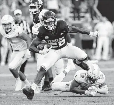  ?? Photos by Bob Levey / Getty Images ?? A&M’s Isaiah Spiller escapes the grasp of Kent State’s Mandela Lawrence-Burke in the first quarter. Spiller and fellow Aggies running back Devon Achane both went for more than 100 yards in Saturday’s opener.